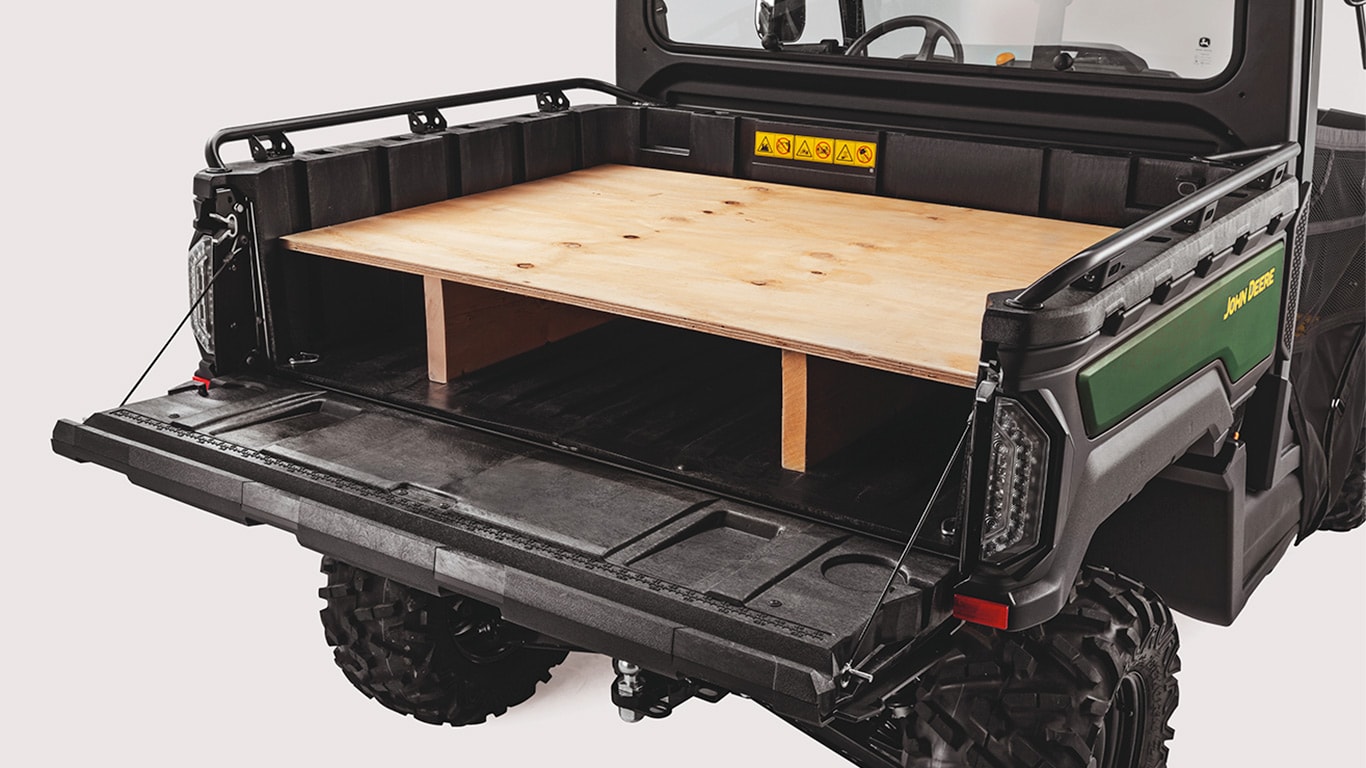 Bakläm på en Gator™ XUV 875M som är nedfälld och används som arbetsbänk