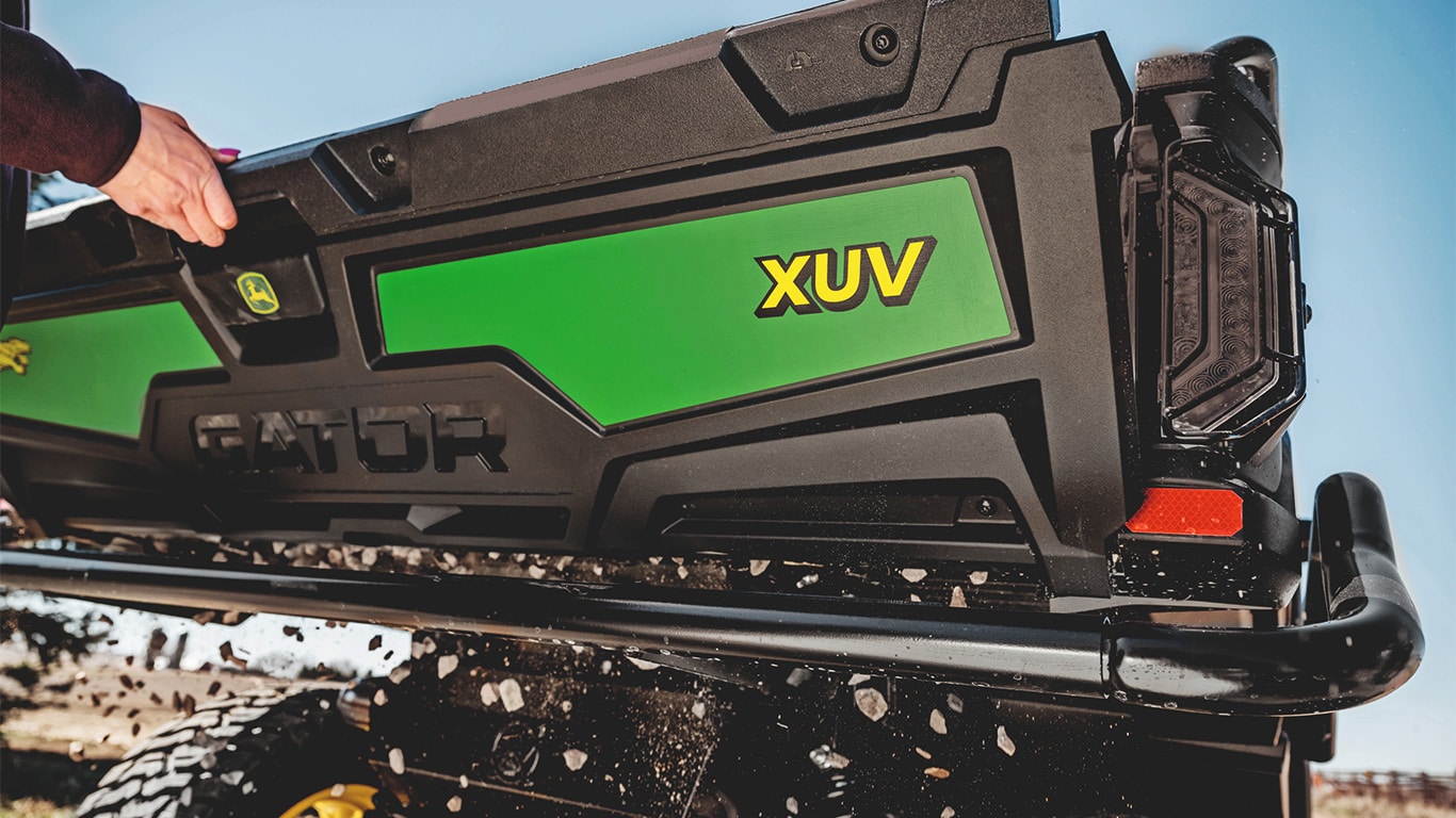 Grus som faller genom bakluckans mellanrum på en Gator™ XUV 875M