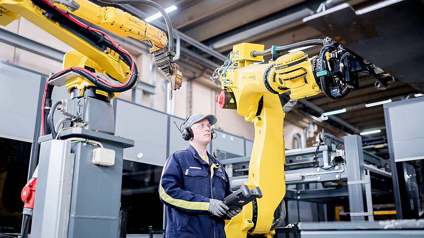 Jarkko Tuononen guidar en robot i fabriken