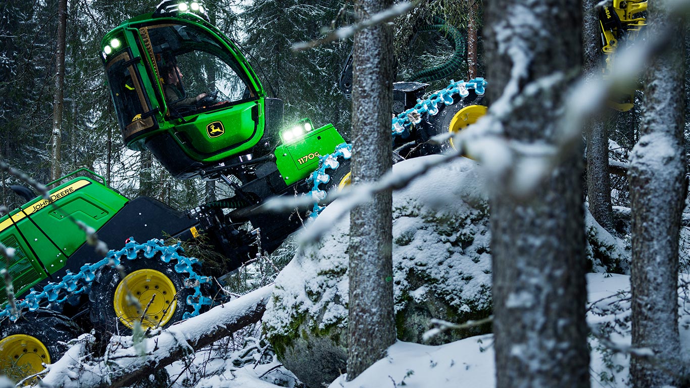 Skördare i en sluttning på vinter