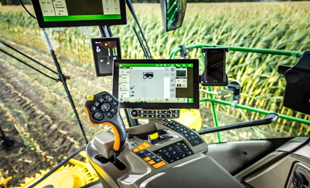 Självgående exakthack F9 700 lastar en Joskin-vagn som dras av en 6R John Deere-traktor