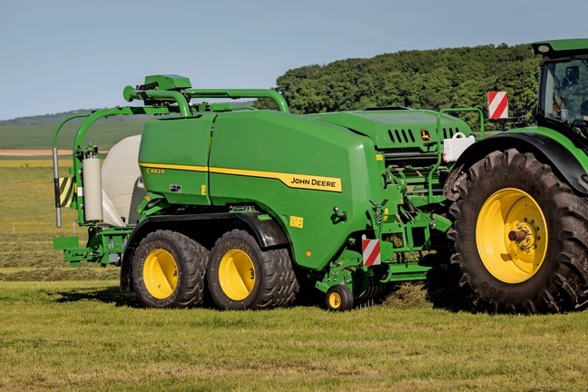 John Deere C442R-inplastarpress som pressar ensilagebalar med hög täthet